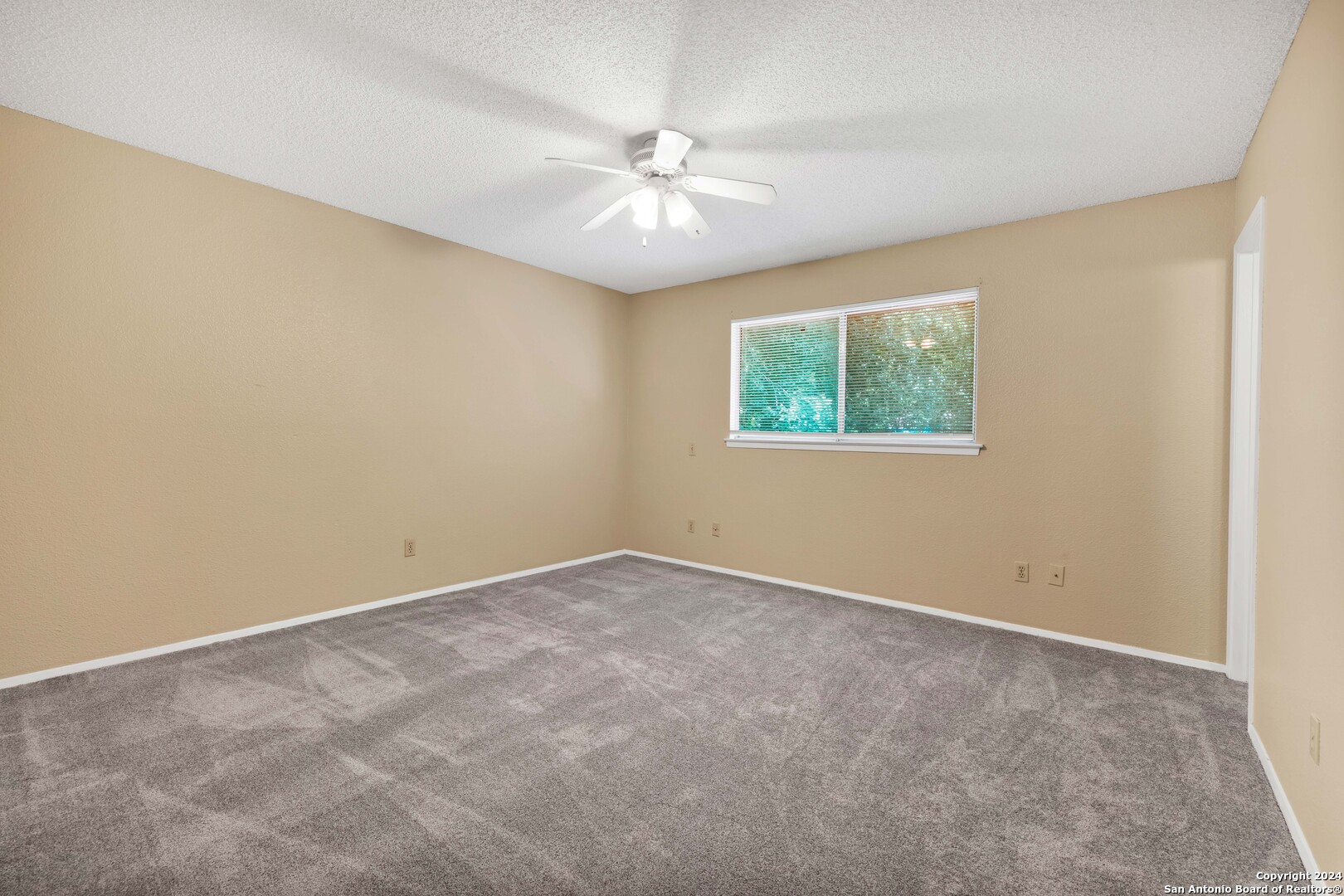 6427 Ridge Pl Street San Antonio, TX 78250 - Photo 9 of 14 an empty room with a window and a ceiling fan