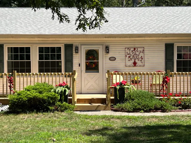 a front view of a house with a yard and potted plants