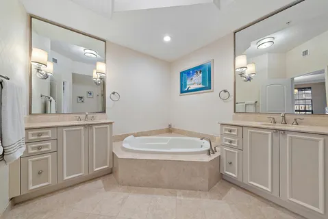 a spacious bathroom with a tub sink shower and mirror