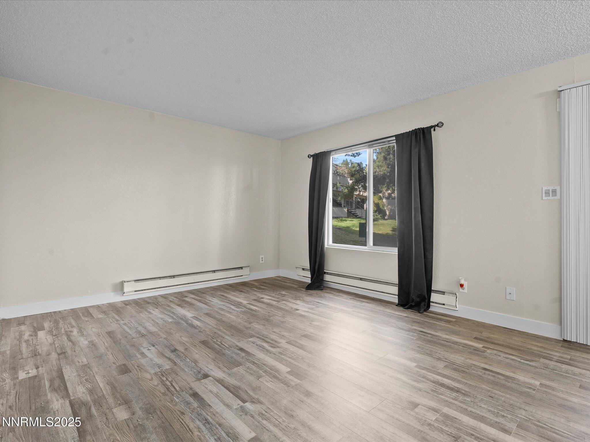 3935 Clear Acre Lane, Unit 215 Reno, NV 89512 - Photo 16 of 31 a view of an empty room with wooden floor and a window