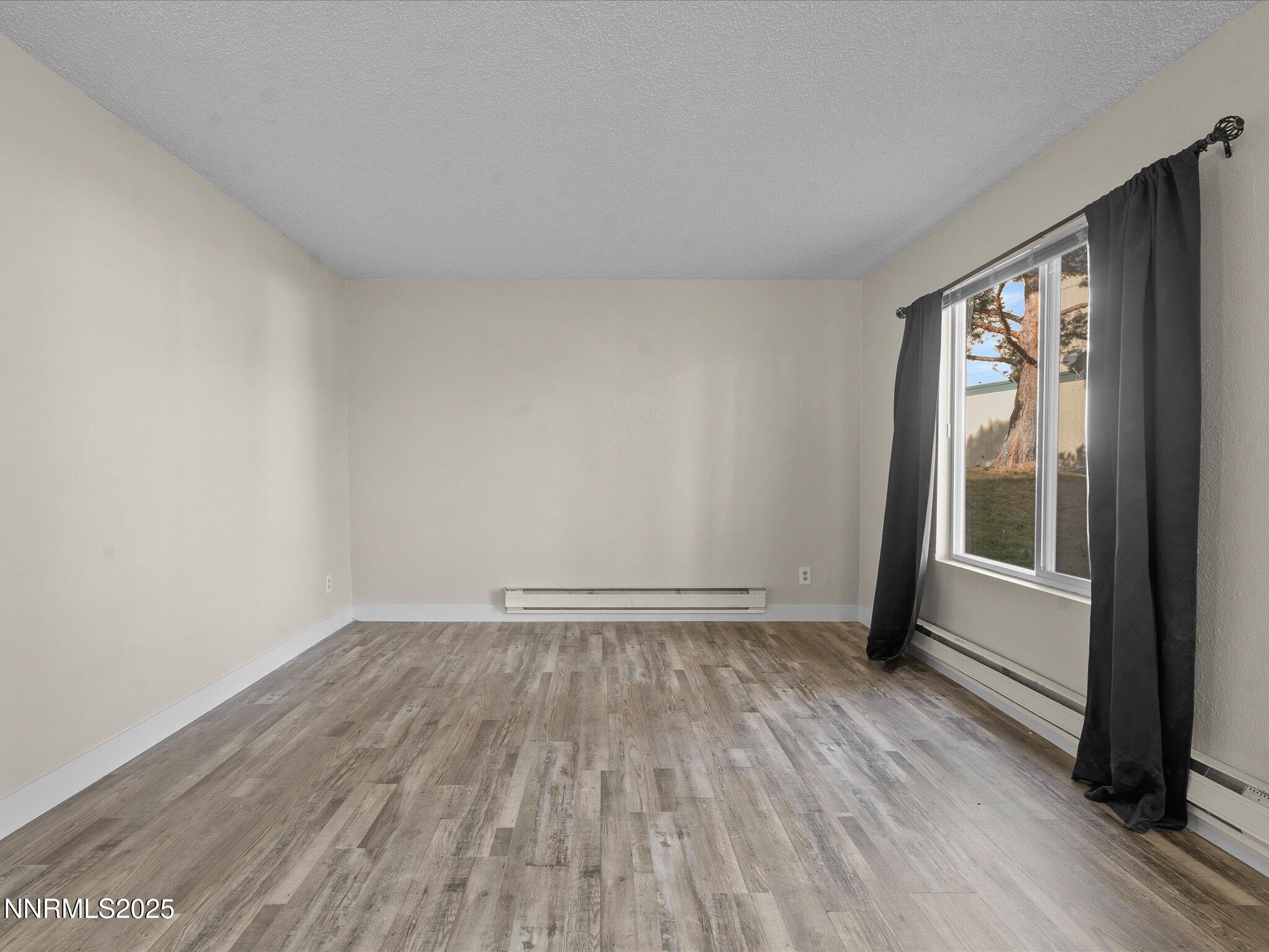 3935 Clear Acre Lane, Unit 215 Reno, NV 89512 - Photo 20 of 31 an empty room with wooden floor and windows