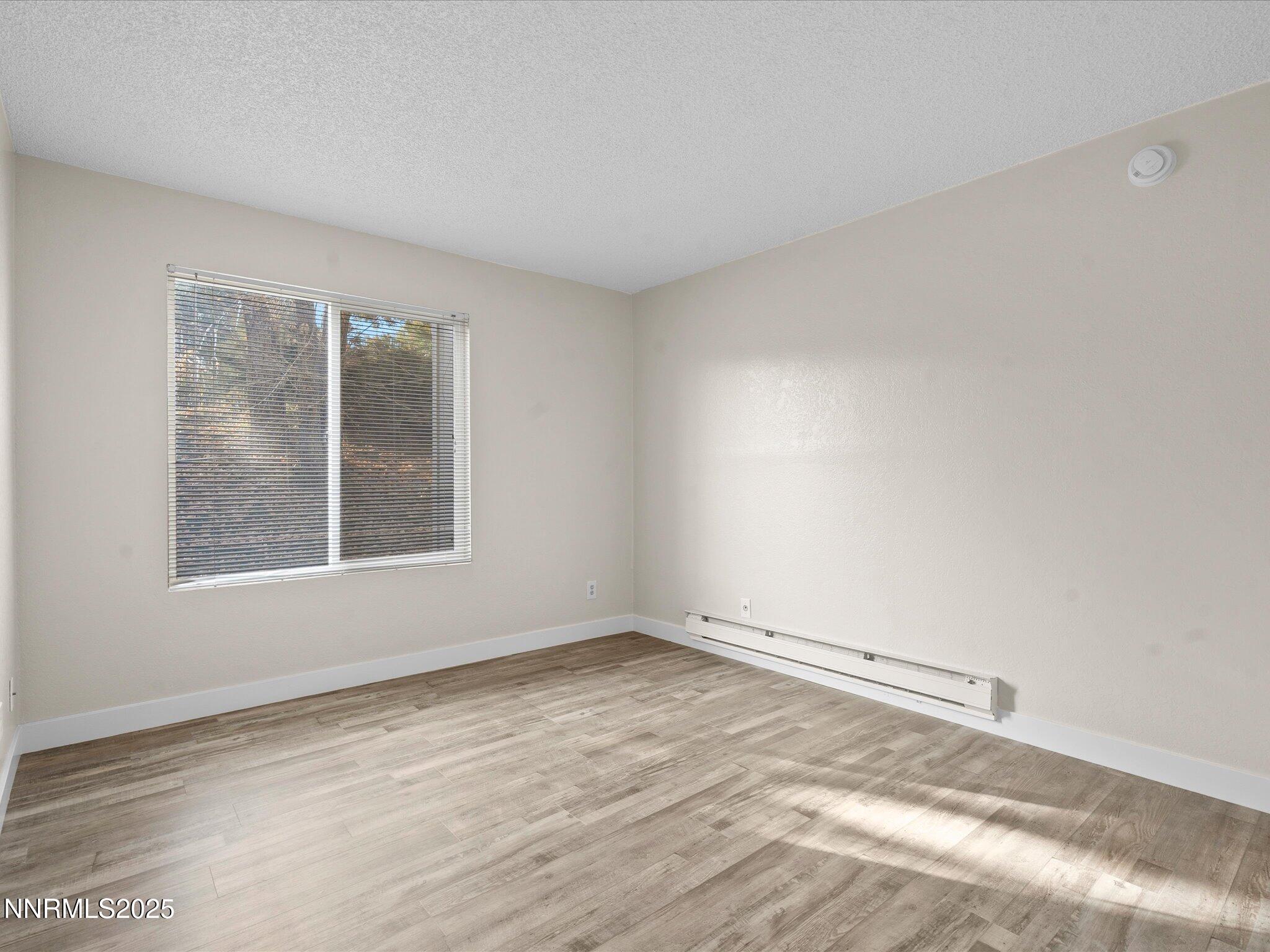 3935 Clear Acre Lane, Unit 215 Reno, NV 89512 - Photo 27 of 31 an empty room with wooden floor and windows