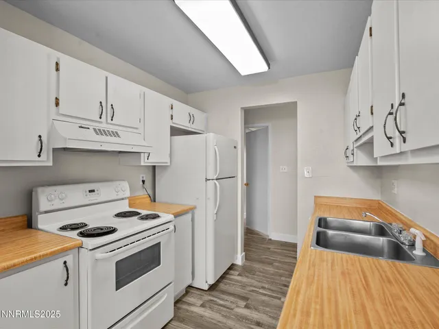 a kitchen with stainless steel appliances granite countertop a sink and a refrigerator