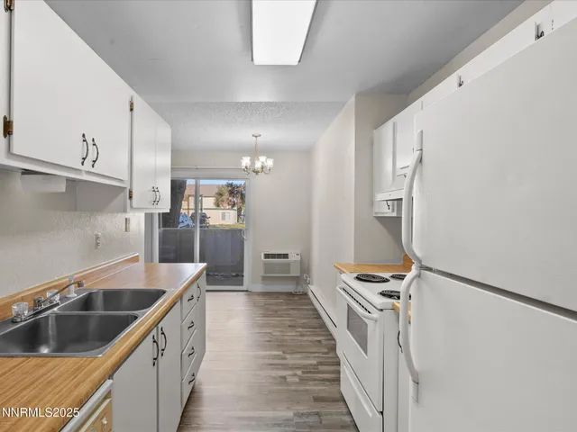 a kitchen with stainless steel appliances granite countertop a sink and a refrigerator