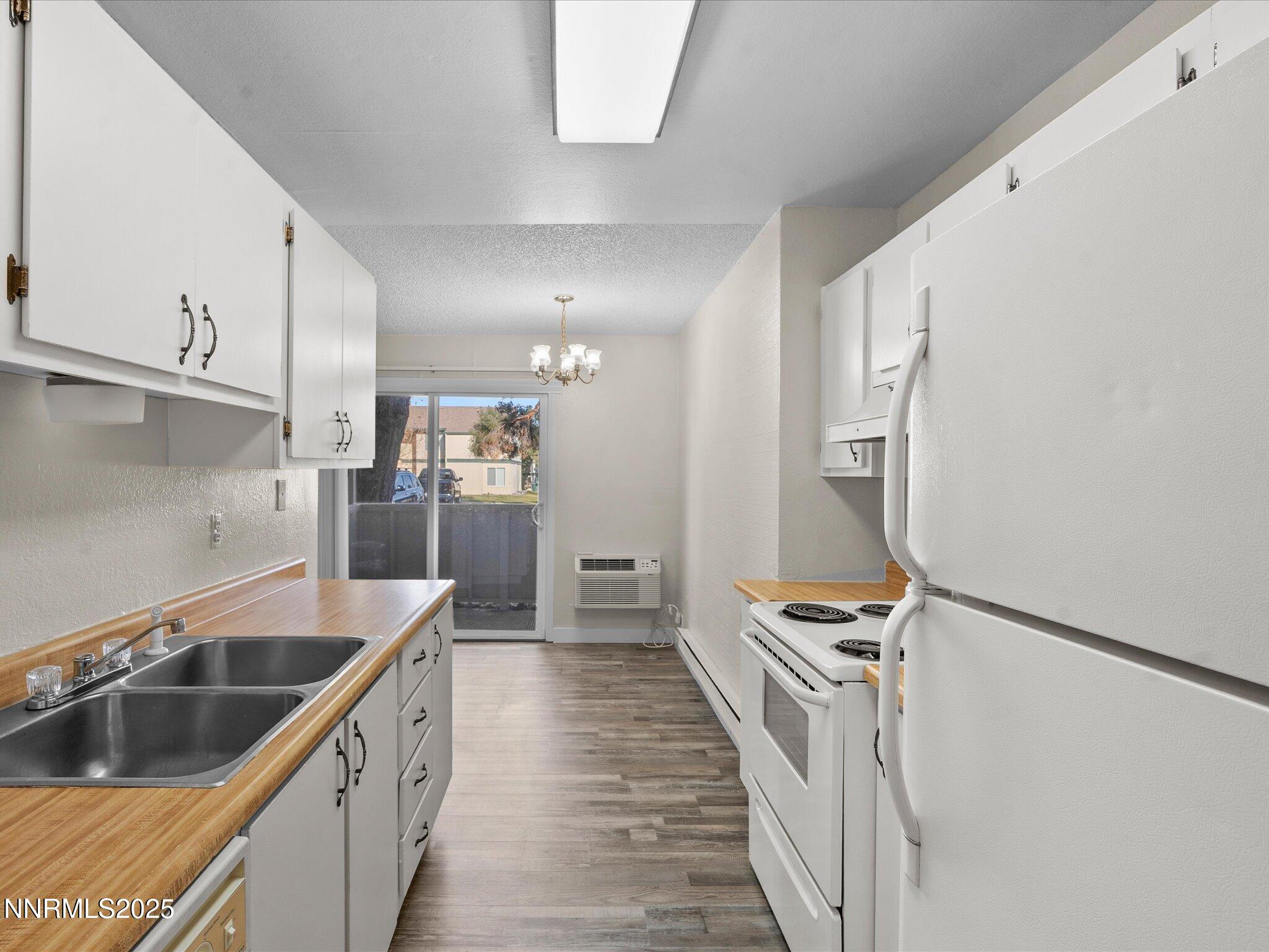 3935 Clear Acre Lane, Unit 215 Reno, NV 89512 - Photo 10 of 31 a kitchen with stainless steel appliances granite countertop a sink and a refrigerator