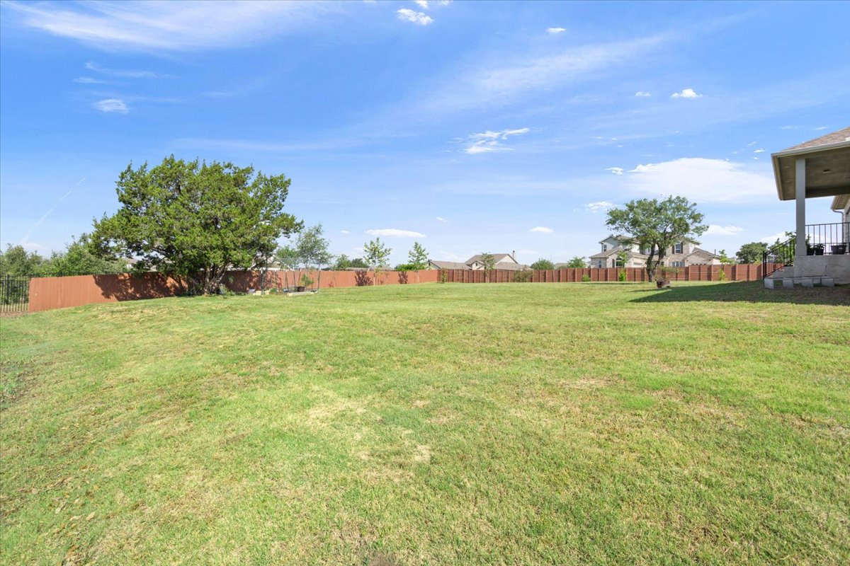 3625 Garrano Bend Leander, TX 78641 - Photo 33 of 38 An expansive green yard, perfect for outdoor living, with a charming tree and fenced perimeter.