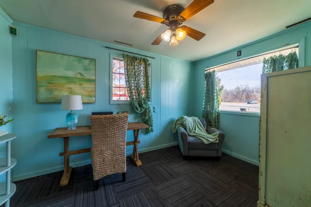 a workspace with wooden floor a flat screen tv and a rug