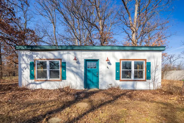 front view of a house with a large window and potted plants