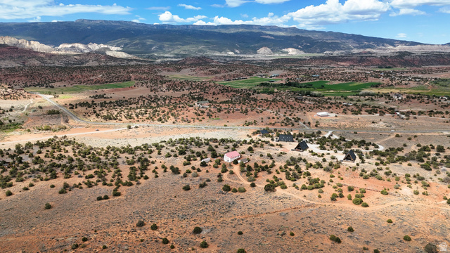358 South Sky Drive Torrey, UT 84775 - Photo 69 of 82 Expansive desert landscape featuring multiple structures, including several A-frame buildings and a single-story residence