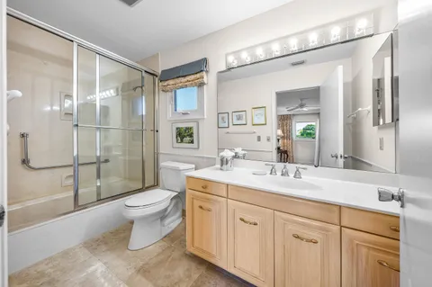 a spacious bathroom with a double vanity sink toilet mirror and shower