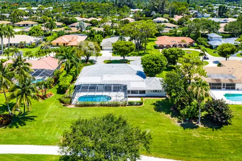 an aerial view of residential houses with yard and lake view