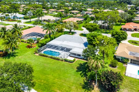 an aerial view of residential houses with outdoor space and trees