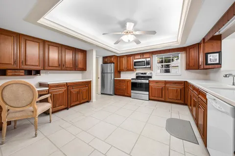 a kitchen with stainless steel appliances granite countertop a stove top oven a sink dishwasher and cabinets with wooden floor