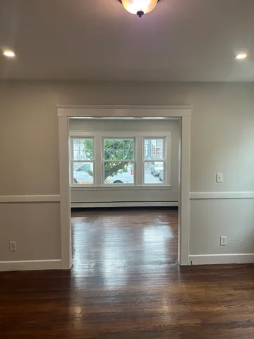 a view of a livingroom with wooden floor and window