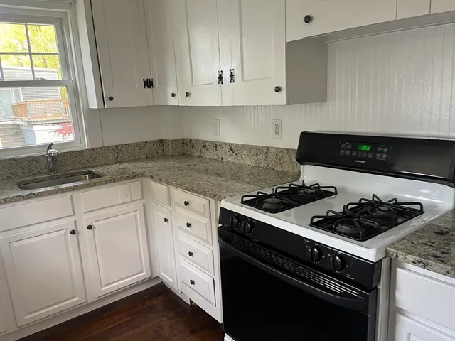 a kitchen with white cabinets and appliances