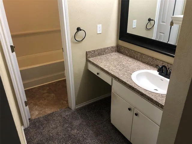 a view of an empty room with a cabinet and a ceiling fan