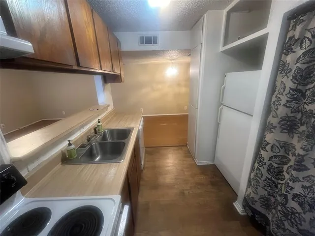 a kitchen with a refrigerator sink and cabinets