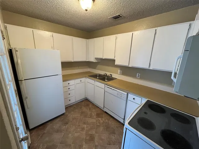 a view of an empty room with a fireplace and a window