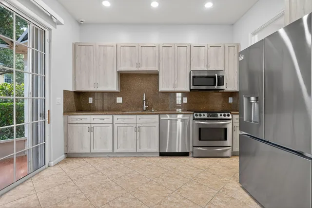 a kitchen with granite countertop a stove a sink and a refrigerator