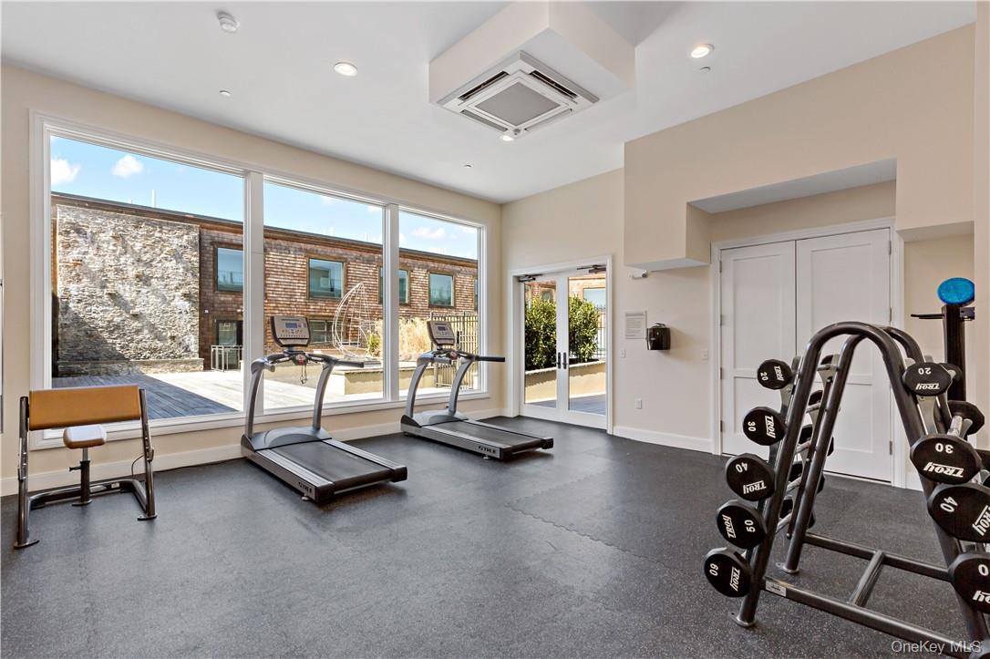 45 Hudson View Way Tarrytown, NY 10591 - Photo 23 of 26 a living room with gym equipment and a floor to ceiling window