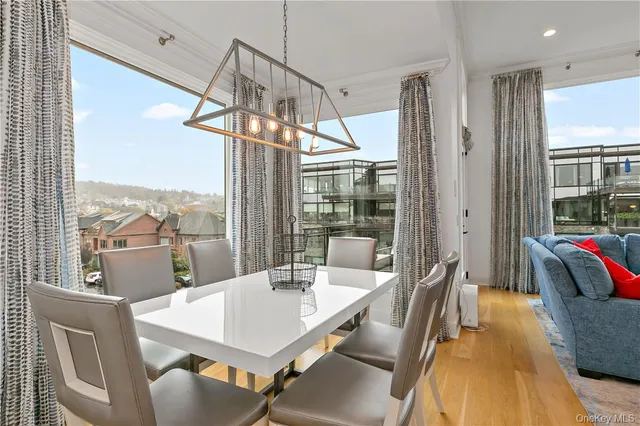 a view of a dining room with furniture large windows and wooden floor