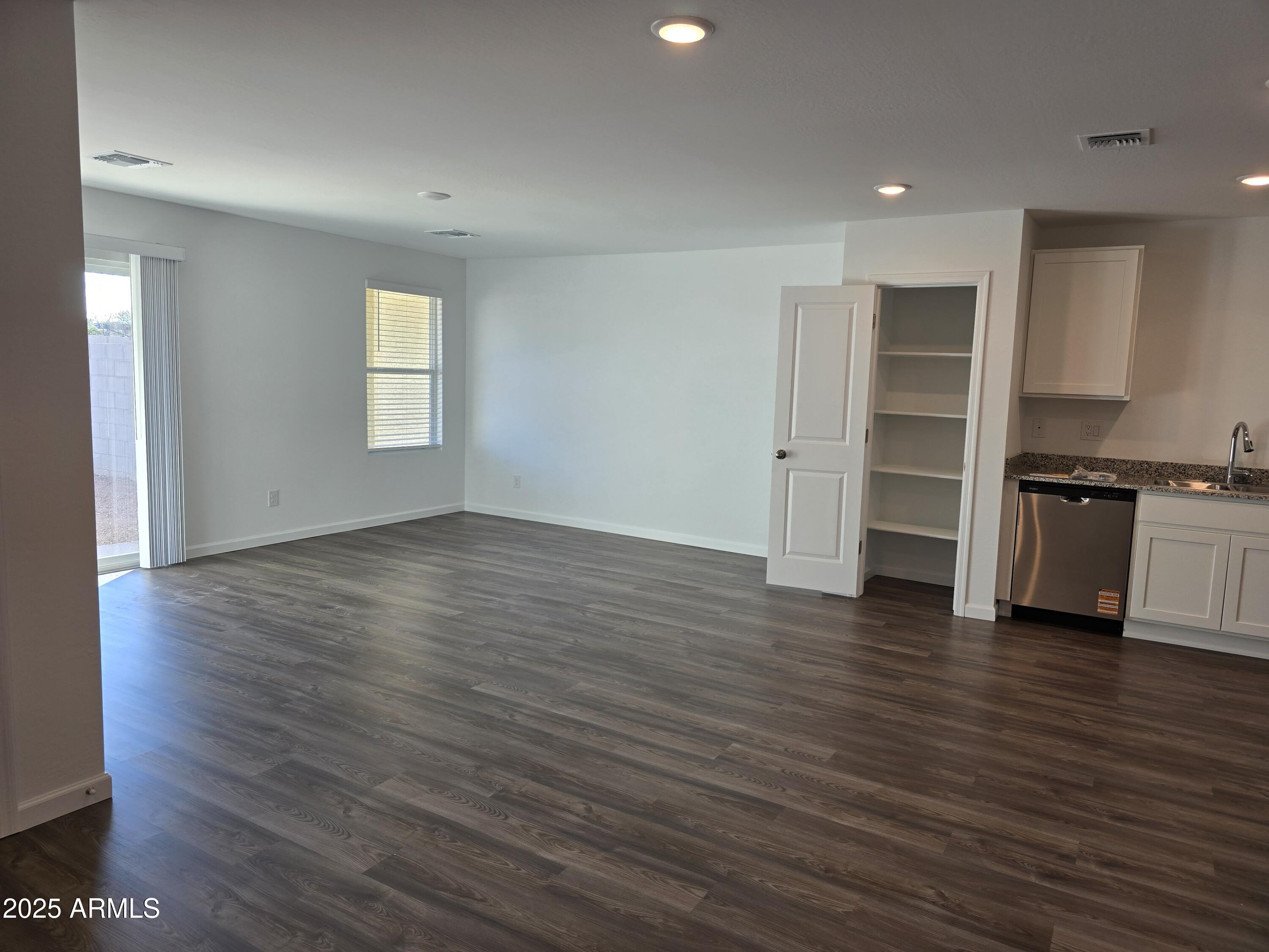 729 Dylan Court Wickenburg, AZ 85390 - Photo 7 of 14 an empty room with wooden floor and windows