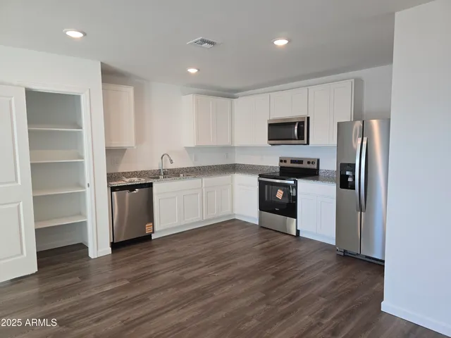 a kitchen with a refrigerator and a stove top oven