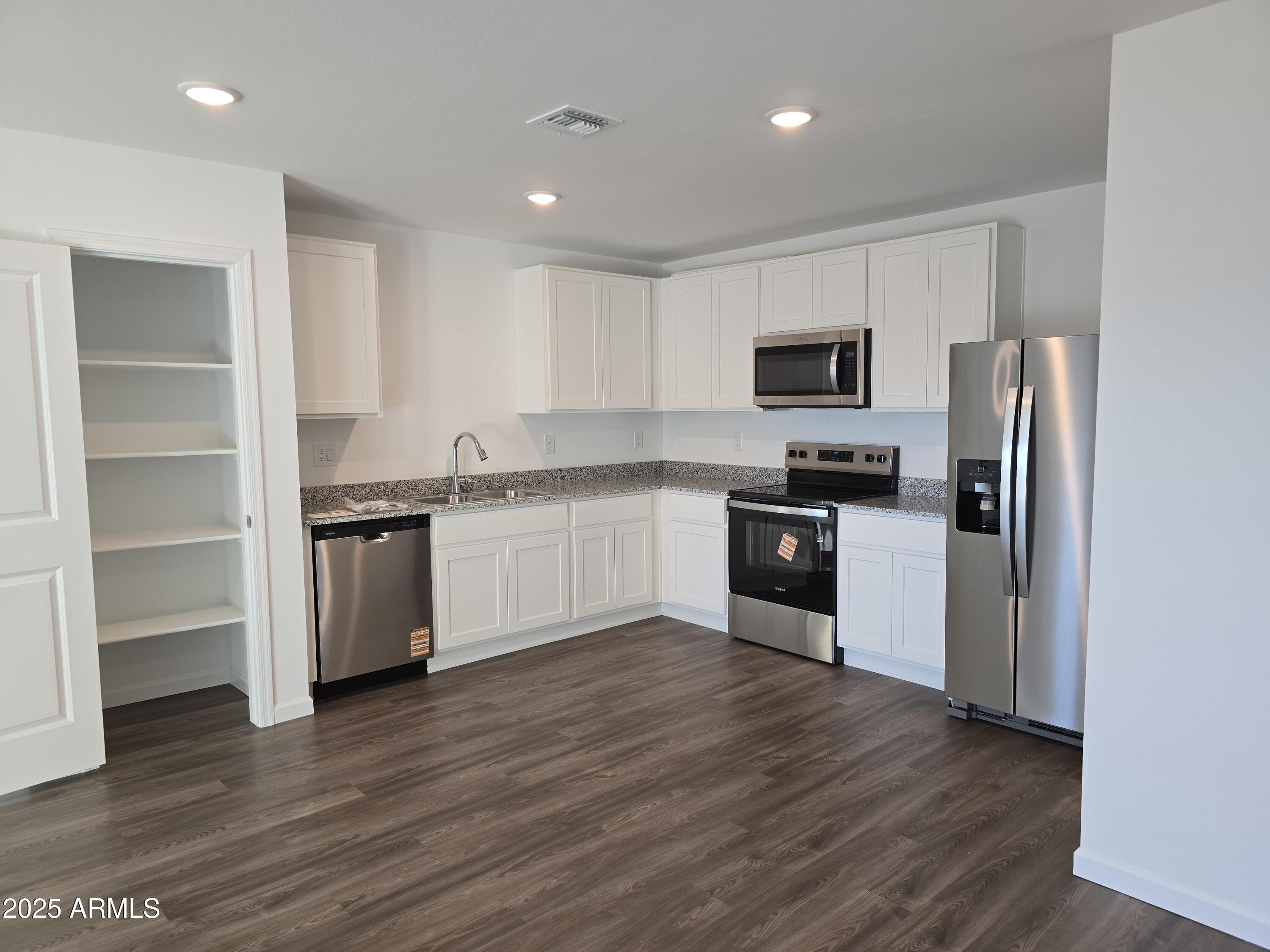 729 Dylan Court Wickenburg, AZ 85390 - Photo 8 of 14 a kitchen with a refrigerator and a stove top oven
