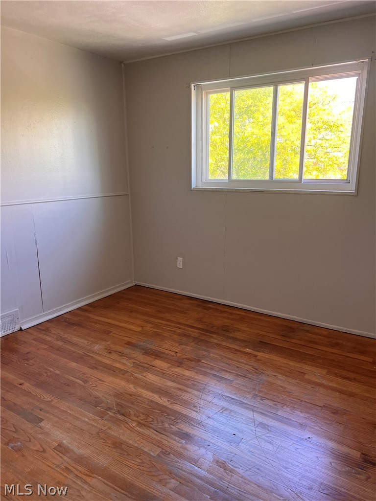 16350 Rockside Road Maple Heights, OH 44137 - Photo 21 of 34 Interior room featuring wood-finish flooring, a white trim baseboard, and a white window frame with a multi-pane slider window