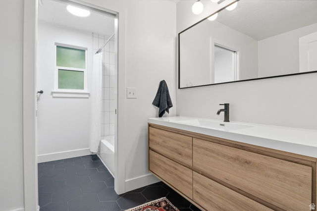 4150 Dover Lane Provo, UT 84604 - Photo 20 of 44 Modern bathroom vanity featuring a light wood-finish with integrated rectangular sink and matte black faucet