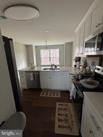 a kitchen with a sink a stove a refrigerator and a window