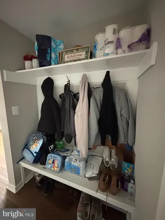 a view of walk in closet with clothes and shoes