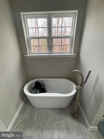 a white bath tub sitting in a bathroom next to a window