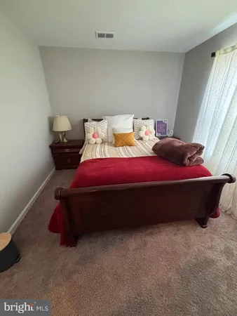 a bed sitting in a bedroom next to a window