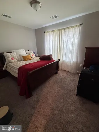 a spacious bedroom with a bed and window