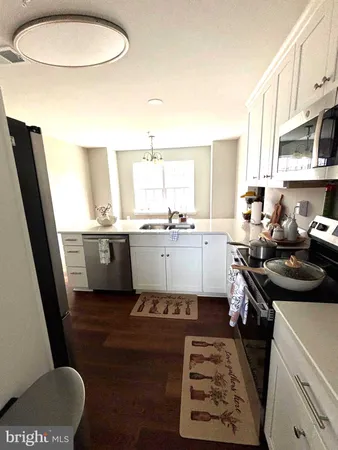 a kitchen with a sink a stove a refrigerator a window and cabinets
