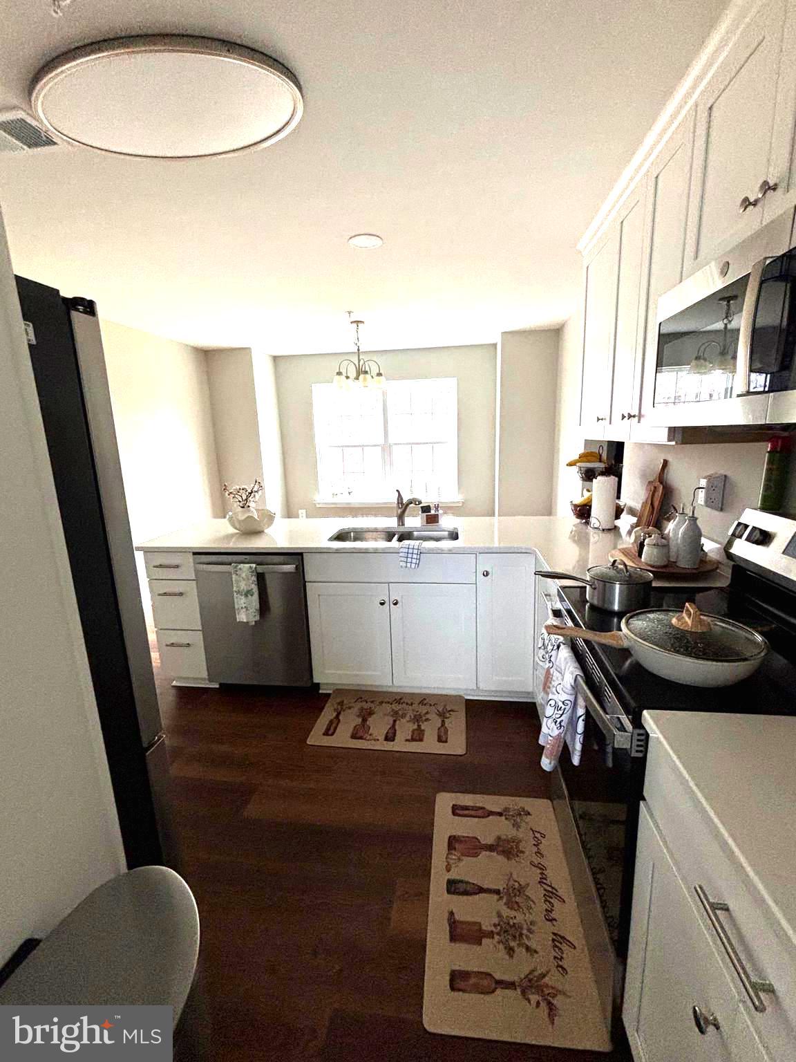 101 Anchor Lane Lusby, MD 20657 - Photo 6 of 45 a kitchen with a sink a stove a refrigerator a window and cabinets