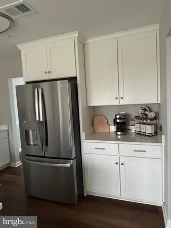 a close view of a refrigerator a sink and dishwasher with wooden floor