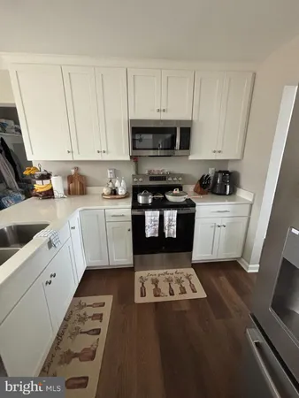 a kitchen with granite countertop a sink a stove and cabinets