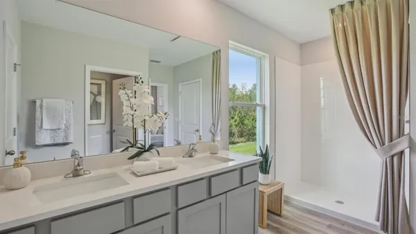 a bathroom with a double vanity sink and a mirror