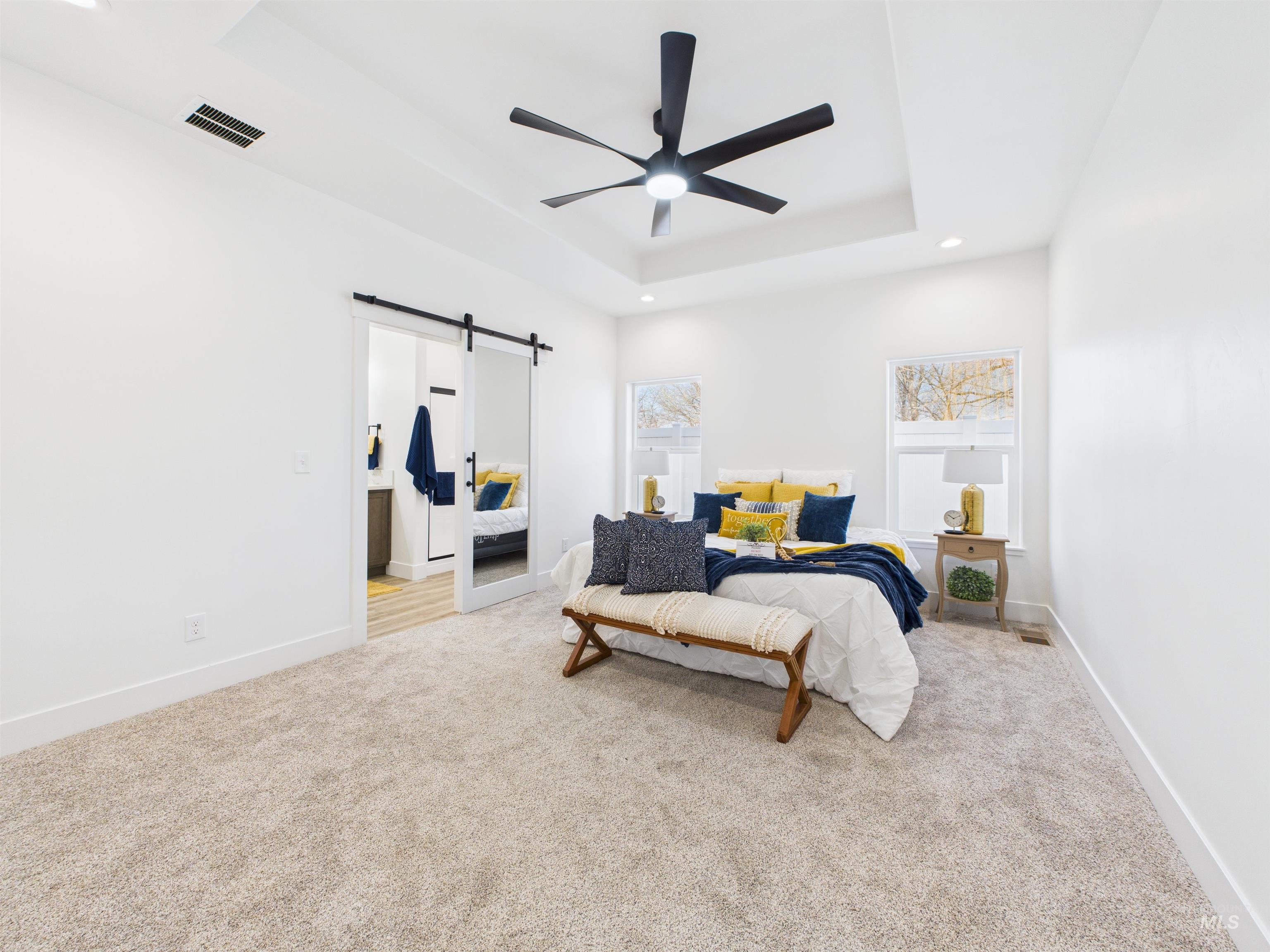 1216 Bronze Drive Rupert, ID 83350 - Photo 12 of 28 Bedroom with a barn door, light carpet, recessed lighting, a tray ceiling, and ceiling fan