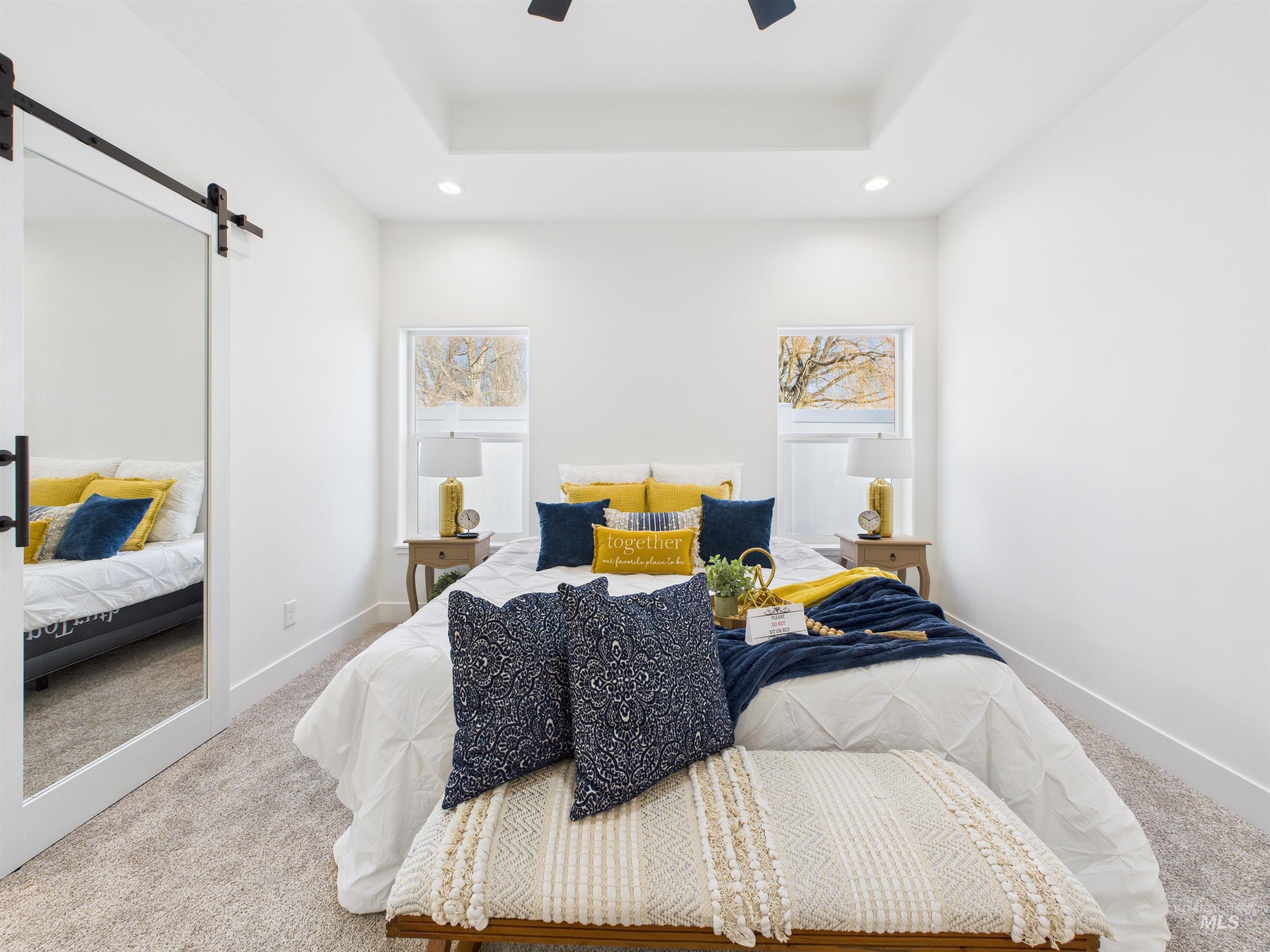 1216 Bronze Drive Rupert, ID 83350 - Photo 14 of 28 Carpeted bedroom featuring a barn door, a raised ceiling, recessed lighting, and a ceiling fan