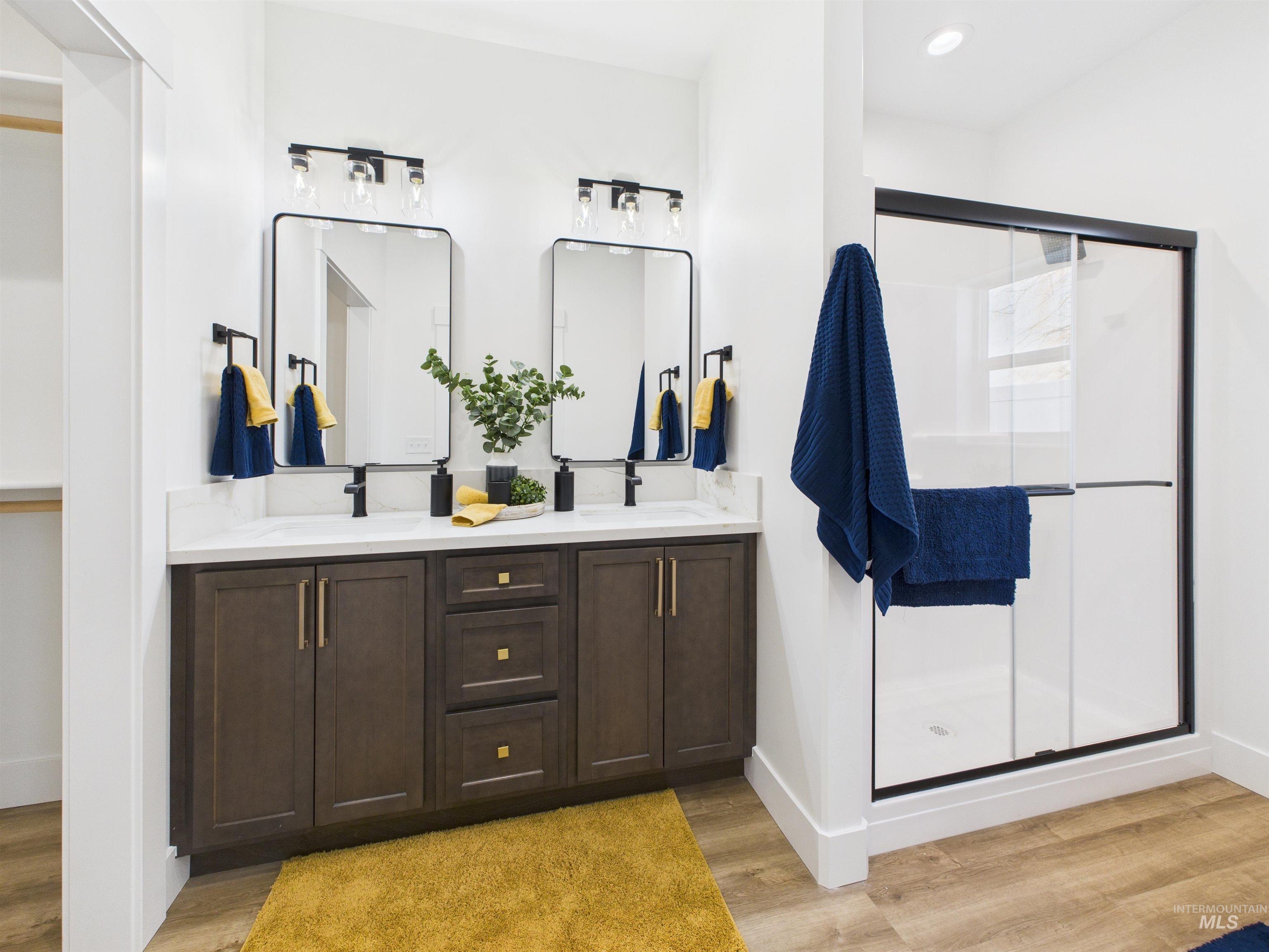 1216 Bronze Drive Rupert, ID 83350 - Photo 15 of 28 Full bath featuring a stall shower, double vanity, and light wood-style floors