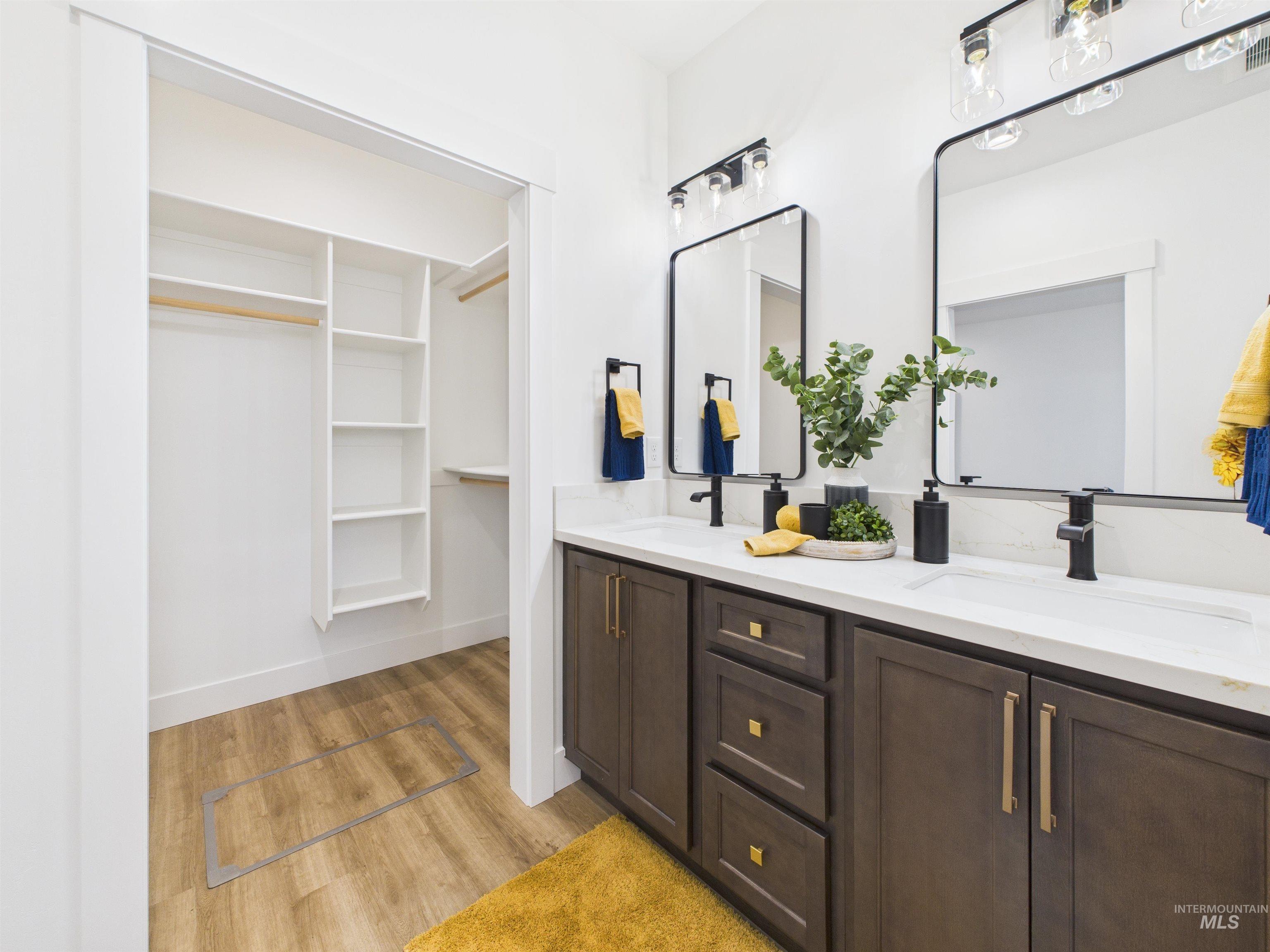 1216 Bronze Drive Rupert, ID 83350 - Photo 16 of 28 Bathroom with a walk in closet, double vanity, and light wood-style flooring