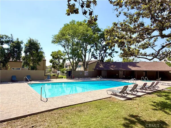a view of swimming pool with lawn chairs and plants