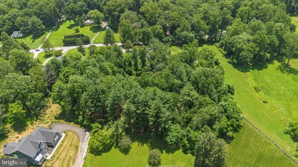 an aerial view of a house with swimming pool and garden