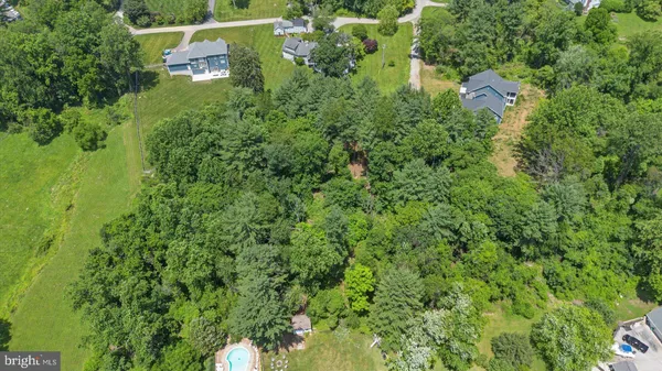 an aerial view of residential houses with outdoor space and trees
