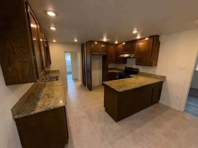 a kitchen with stainless steel appliances granite countertop a refrigerator and a stove