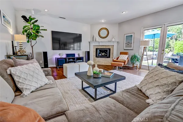 a living room with furniture a fireplace a flat screen tv and a large window