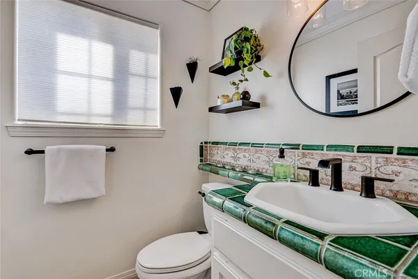 a bathroom with a granite countertop toilet sink and mirror